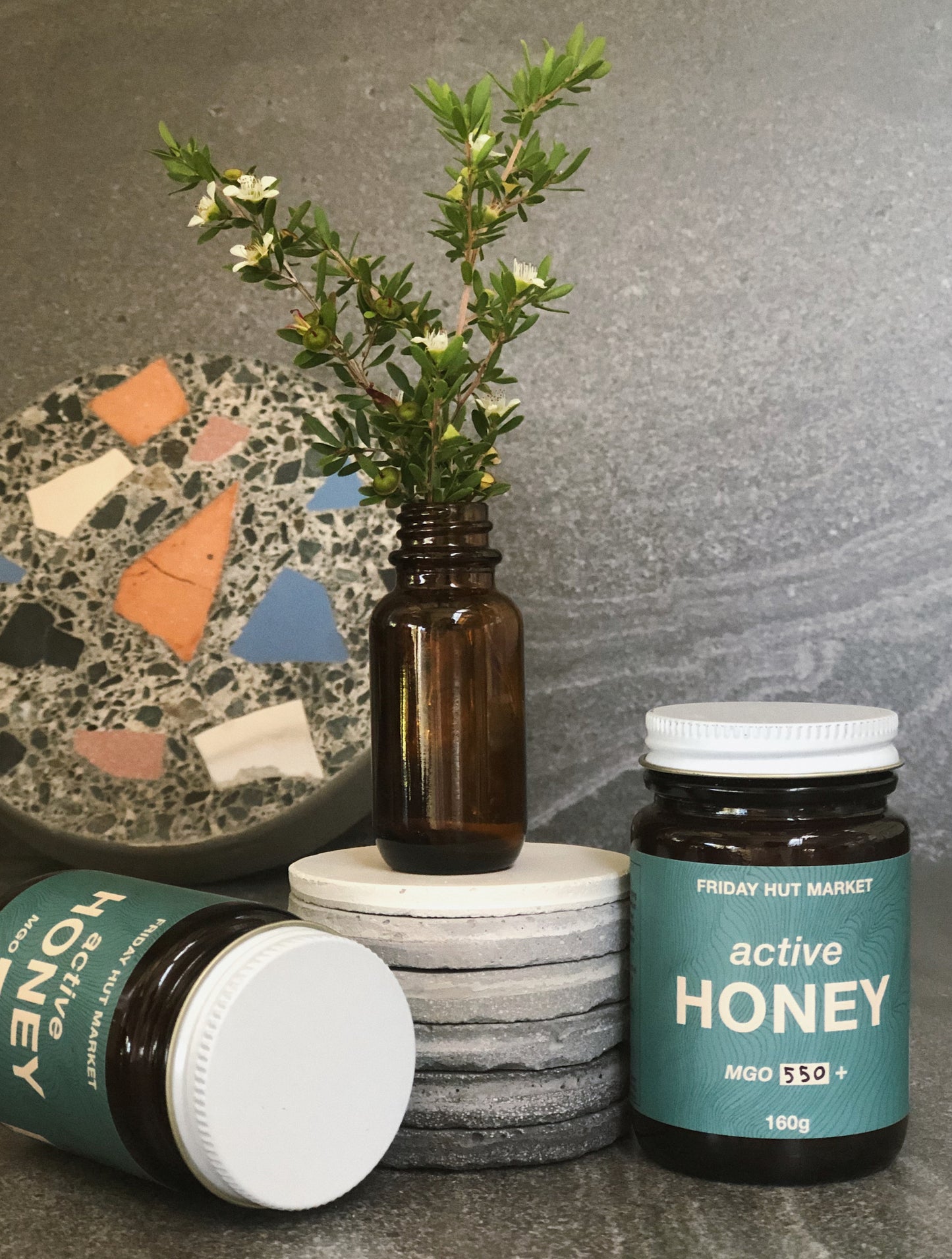 Picked Leptospermum Jellybush flowers with jars of Friday Hut Market Active Jellybush Honey. Australia's Manuka