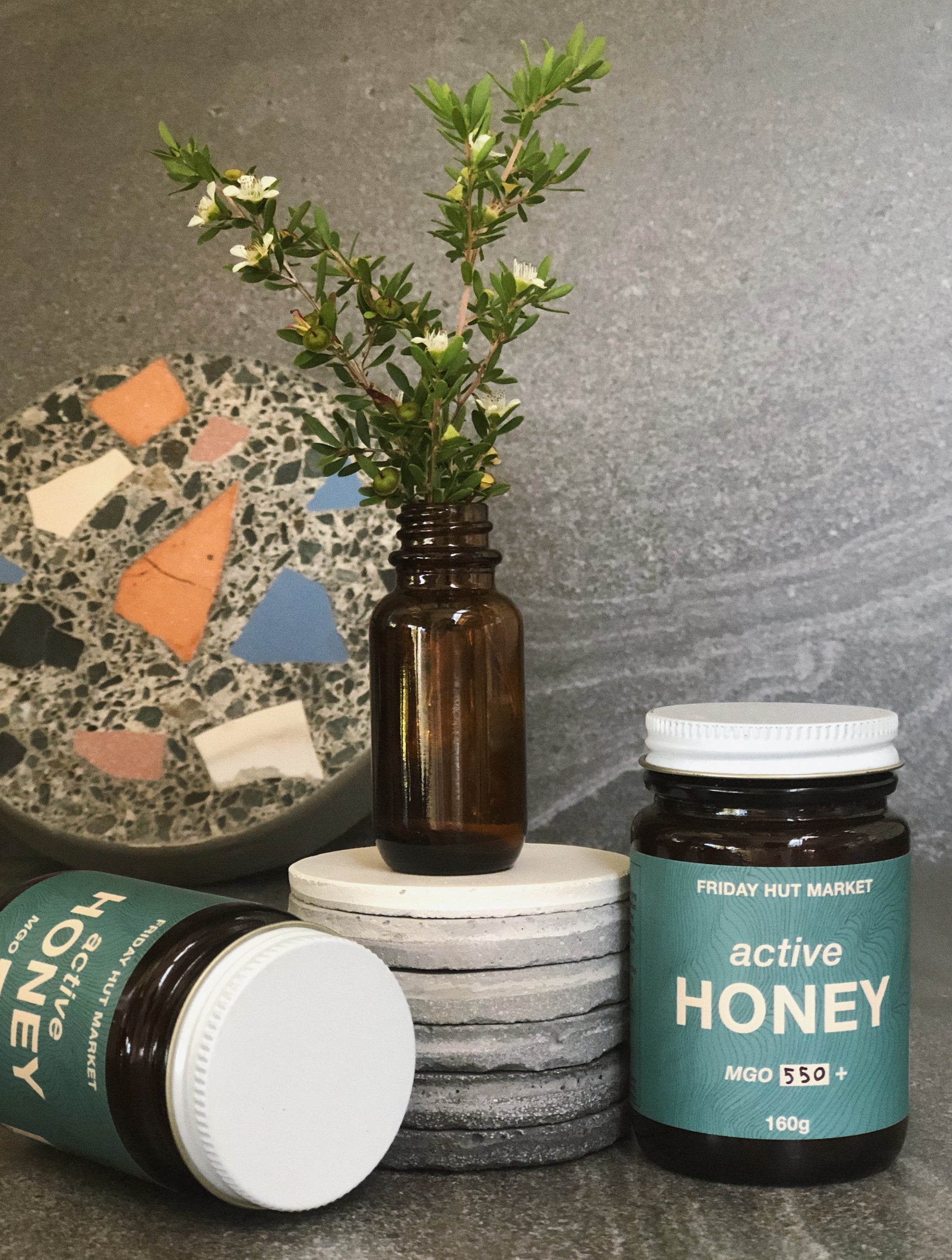 Picked Leptospermum Jellybush flowers with jars of Friday Hut Market Active Jellybush Honey. Australia's Manuka